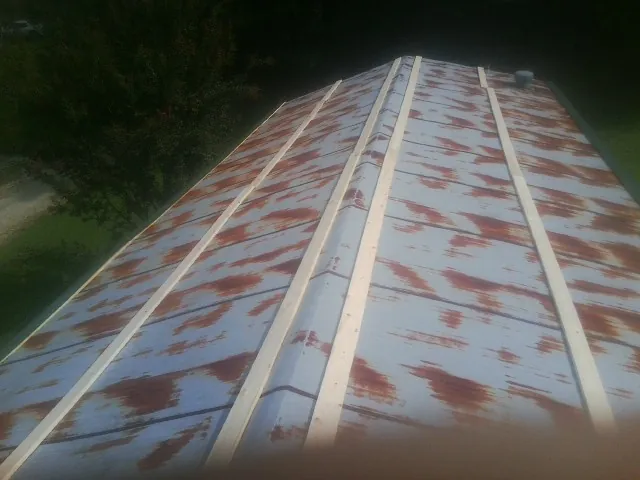 Rusted metal roof panels with new wood purlins before replacement — Storm Damage Roof Repair in Poole by Roofing Brothers