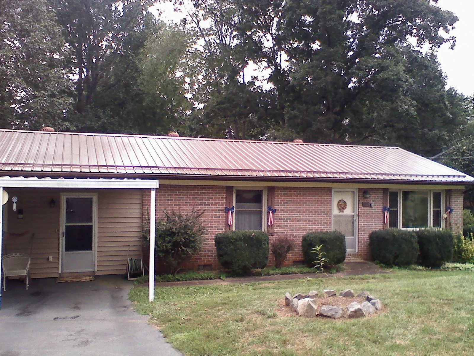 Bronze metal roof and carport on a brick ranch home — Roof Repair work by our crew in Poole